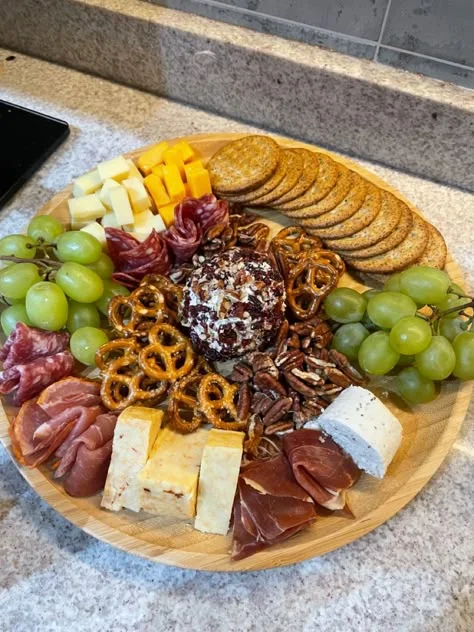 Tabla de quesos, carnes frías, uvas y galletas: referencia de charcutería